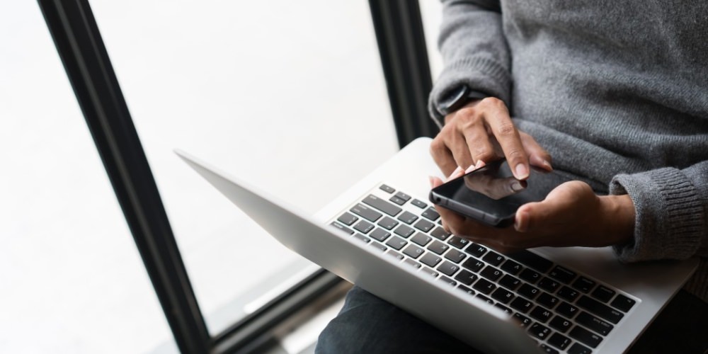 Don't buy Facebook likes - man on laptop and phone